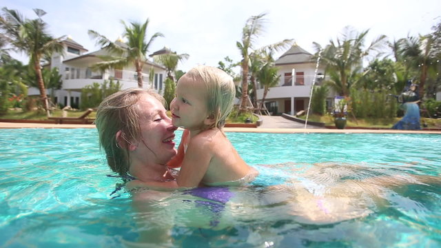 blonde little girl climbs mother swimming pool and play prank