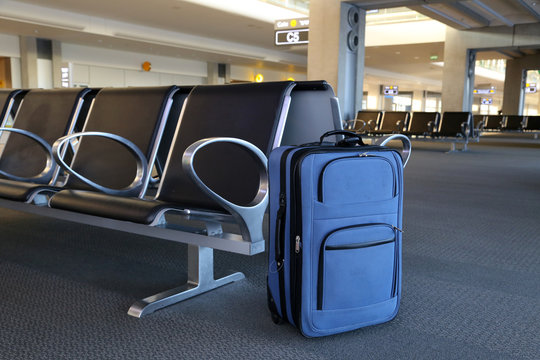 Blue suitcase at airport gate.