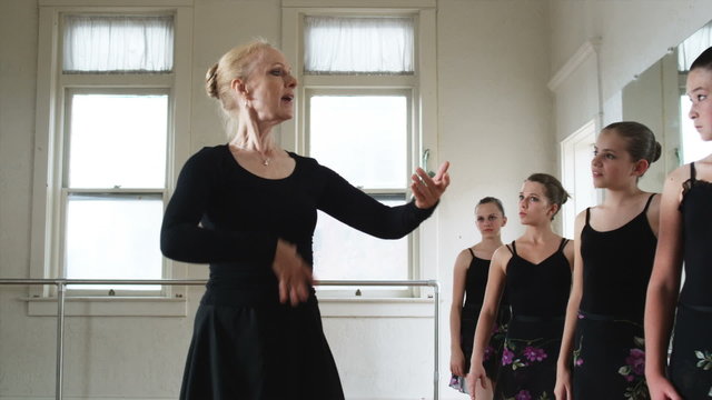 young ballerinas in a row with instructor