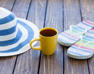 Cup of coffee and hat with flip flops