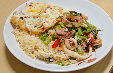 spicy fried squid with basil leaves topping fried egg