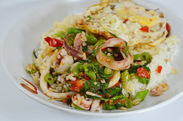spicy fried squid with basil leaves topping fried egg
