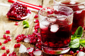 Fresh red juice cocktail with pomegranate seeds, mint and ice, s