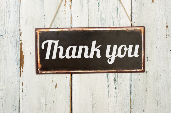 Old metal sign in front of a white wooden wall - Thank you