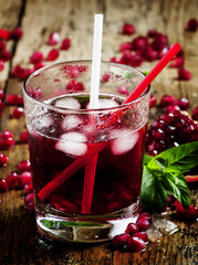 Fresh red juice cocktail with pomegranate seeds, mint and ice, s