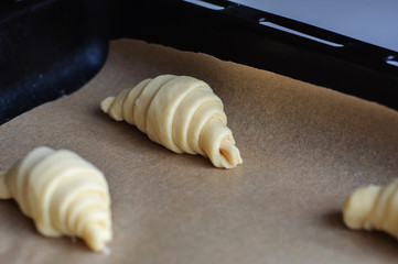 Fototapeta na wymiar Not baked croissants on oven-tray