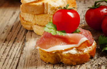 Traditional Italian antipasti crostini with ham, cheese and toma