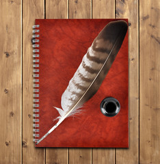 Notebook and feather with ink bottle