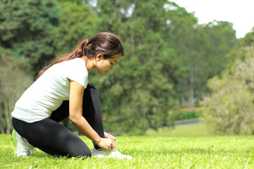 sporty woman tying her shoelace during workout