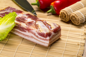 still life with bacon, salad, red bell pepper and a kitchen knif