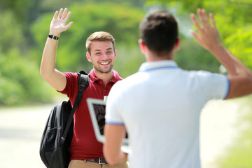 Naklejka premium college student meet his friend and waving his hand