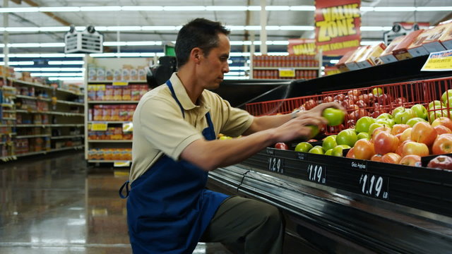 grocery clerk putting apples away