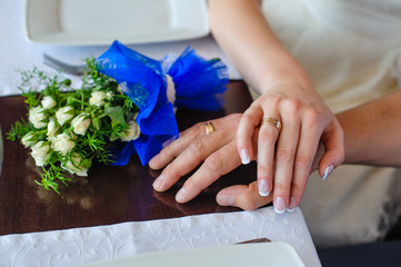 Hands of the groom and the bride with wedding rings