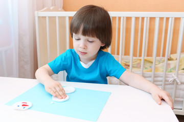 Naklejka premium Nice boy makes snowman of cotton pad
