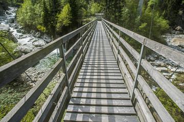 Fototapeta na wymiar Fussgängerhängebrücke über die Reuss bei Silenen, Uri, Schweiz