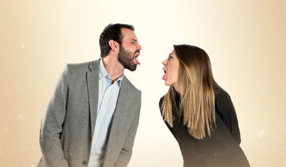 Couple sticking out her tongue over white background