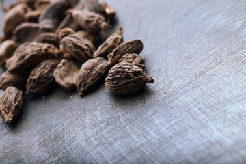 Seeds of black cardamom on the wooden table