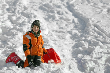 Fototapeta na wymiar cute boy with wool cap in the winter plays with bob in the mount