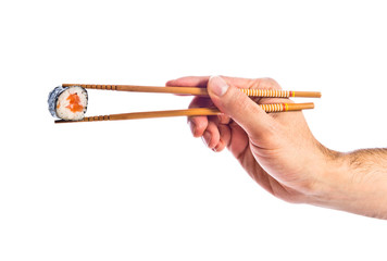 hand holding sushi with chopsticks © luismolinero