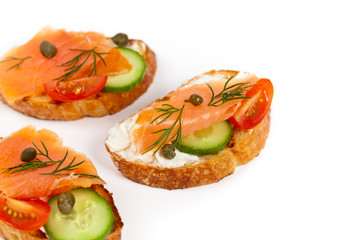 Finger food canape with smoked salmon on white background