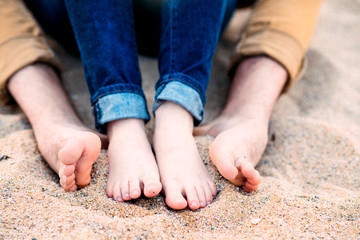 Barefoot feet of the couple on the beach sand - 82547502