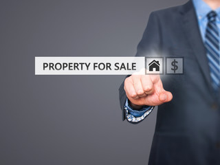 Businessman pressing property for sale button