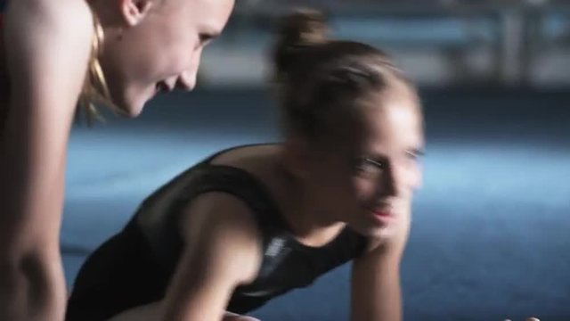 CU PAN Four girls (8-9, 10-11) laughing and stretching in gym, Orem, Utah, USA