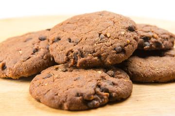 Homemade cookies with chocolate and hazelnuts on a wooden plate