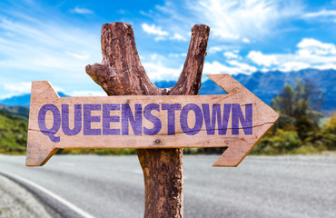 Queenstown wooden sign with road background