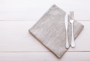 Cutlery, tablecloth on white wooden table for dinner.