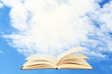 Opened book on sky background
