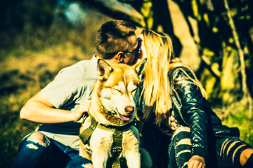 Portrait of husky dog outdoor with kissing couple behind