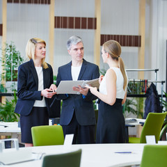 Geschäftsleute im Büro mit Akte reden