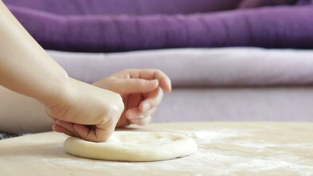 Female hand mold of pie dough and sprinkle with flour