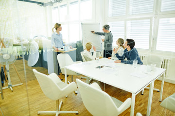 Mann neben Flipchart in Meeting