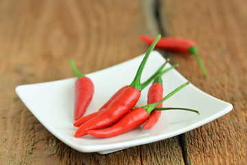 Chilischoten auf Teller und Holztisch