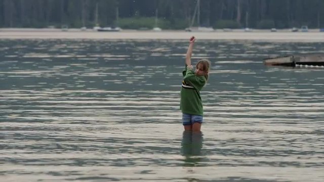 Medium shot of girl playing in lake / Redfish Lake, Idaho, United States