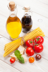 Pasta, tomatoes, basil on wooden table