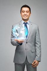 happy businessman in suit showing globe hologram