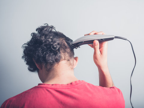 Young Man Cutting His Hair At Home