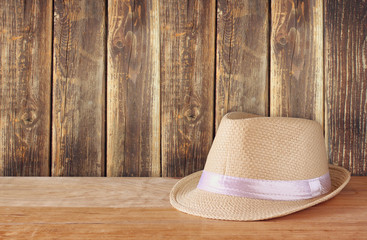 fedora hat over wooden table and wooden background
