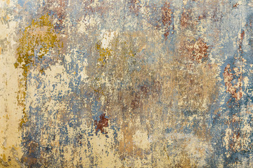 old grunge wall of an old house with remainings of color