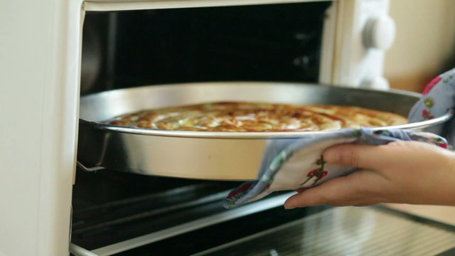 Hands in the Kitchen gloves are removed from the oven cooked pie