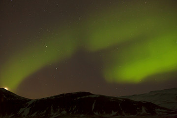 Fototapeta na wymiar Northern lights with snowy mountains in the foreground