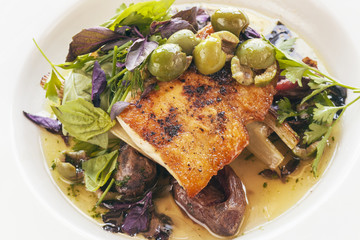 white seabass with olives and organic greens