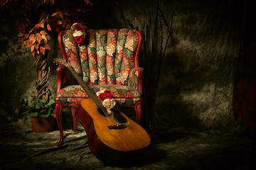 Vintage Acoustic Guitar Leaning Against Antique Chair