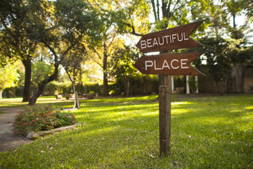 wooden garden sign reading "Beautiful Place", pointing down the