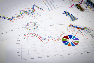 stack of paper documents with financial reports and statistic in
