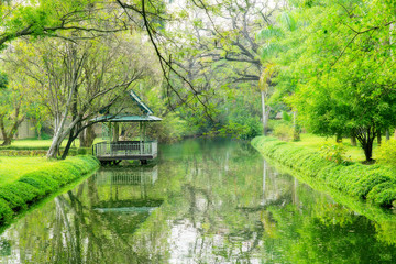 Fototapeta na wymiar Beautiful green garden with canal and pavilion
