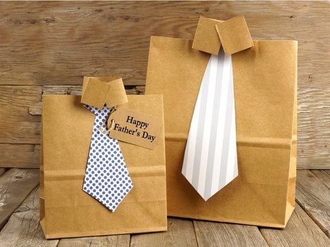 Fathers Day shirt and tie gift bags on a wood background
